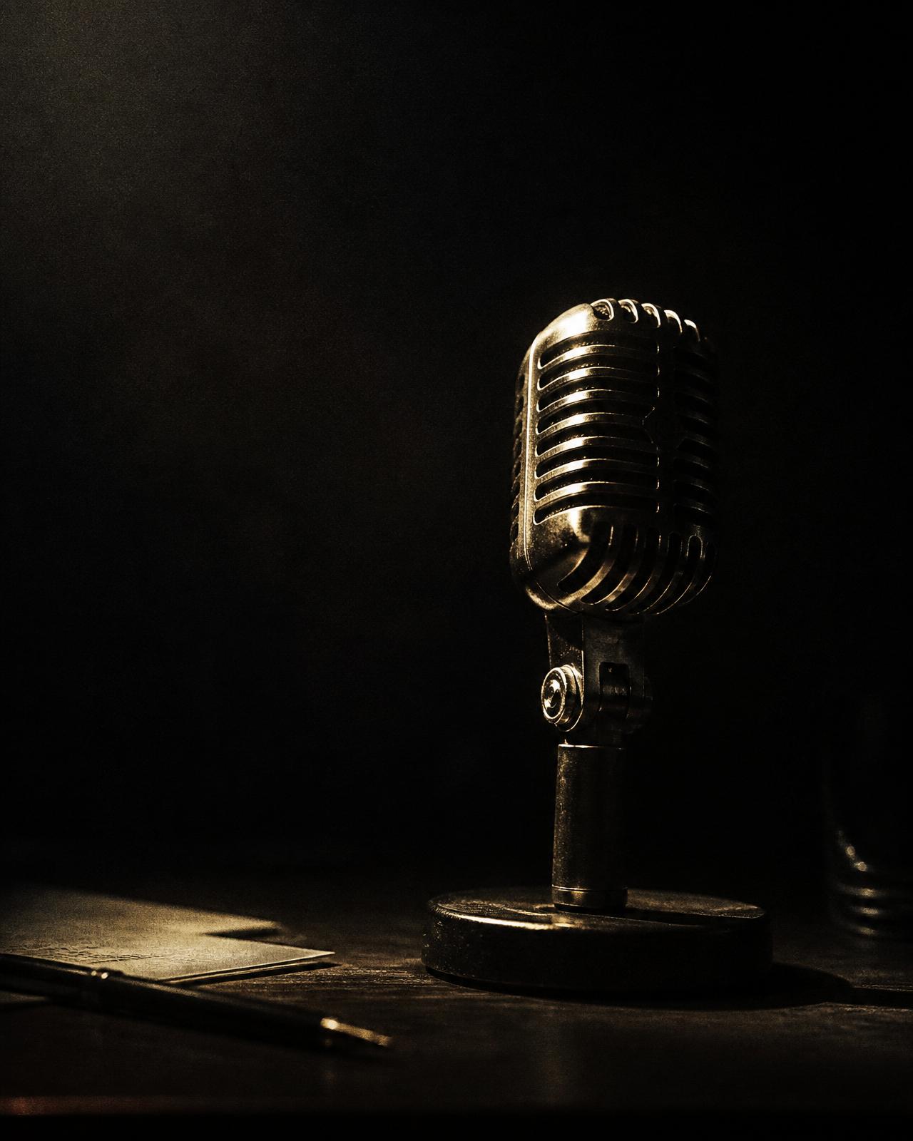 A vintage broadcast microphone lit by a single warm light